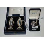 A lot comprising a cased pair of silver condiments and a cased sterling silver scent bottle with