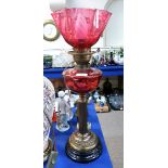 A cranberry glass and brass oil lamp, 57cm high, the knobs marked Duplex Condition Report: Available