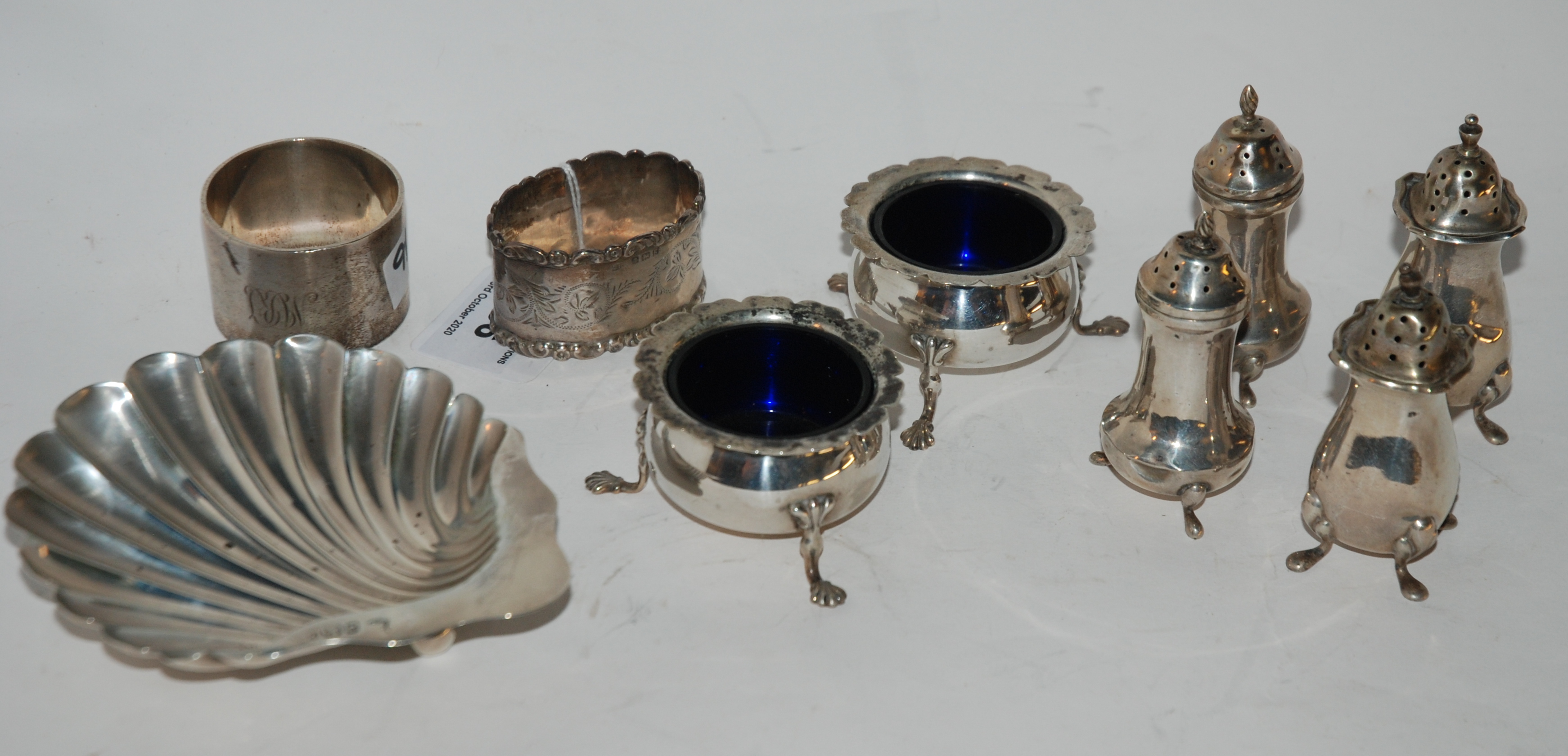 A lot comprising a silver shell shaped butter dish, two silver napkin rings and six assorted