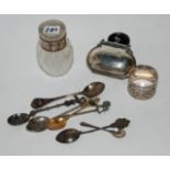 A lot comprising a silver mounted scent bottle, a sliver purse, napkin ring and some souvenir spoons