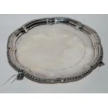 A silver card tray, Sheffield 1966 of circular form with gadrooned rim on three scrolling feet,