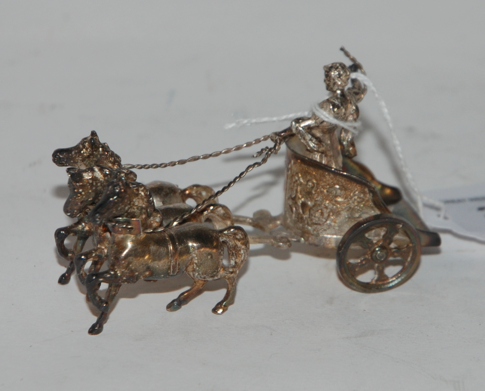 A miniature silver model of a three-horse chariot and driver, 9cm long bearing import marks,