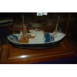 A model boat in glazed case, 65cm wide overall, another model and model of Archibald Russell in