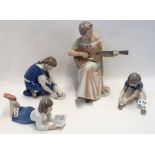 A Bing and Grondahl figure of a seated woman playing a guitar, a girl and a cat, a girl lying down