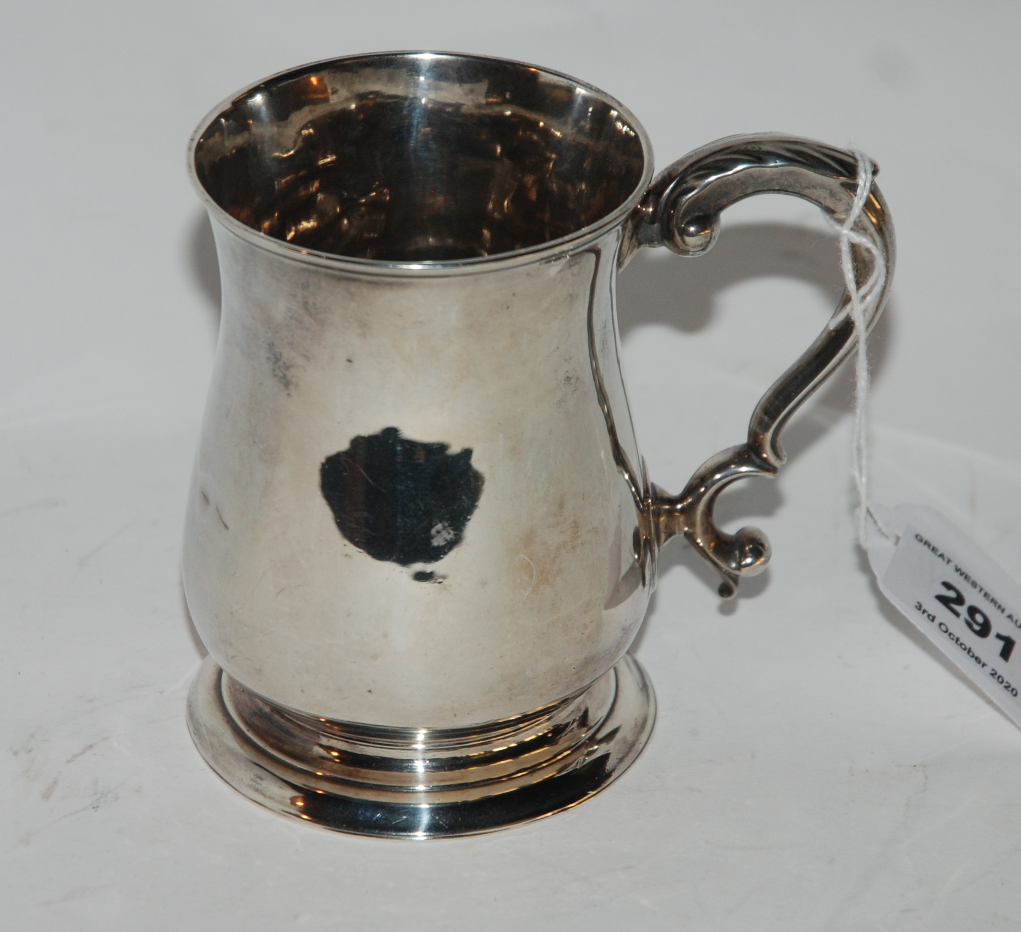 A silver tankard unclear Georgian London marks of plain baluster form with scrolling handle, 10cm