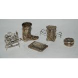 A lot comprising a silver vesta, a white metal pill box, a cocktail stick holder modelled as a boot,