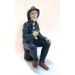 A Lladro figure of a fisherman sitting down Condition Report: Available upon request