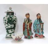 A Chinese porcelain bowl decorated with a couple, a pair of pottery figures and a green dragon
