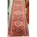 A red ground Karajeh runner with three central lozenges, 208cm x 72cm Condition Report: Available