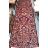 A red ground Karejeh runner with five central lozenges, 356cm x 104cm Condition Report: Available