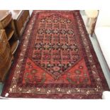 A red ground Baluchi rug with allover geometric design, 296cm x 157cm Condition Report: Available