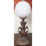 A Black Forrest table lamp of carved birds with a white globe, 60cm high Condition Report: Available