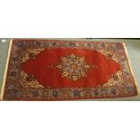 A red ground eastern rug with central medallion and signature, 150cm x 78cm Condition Report: