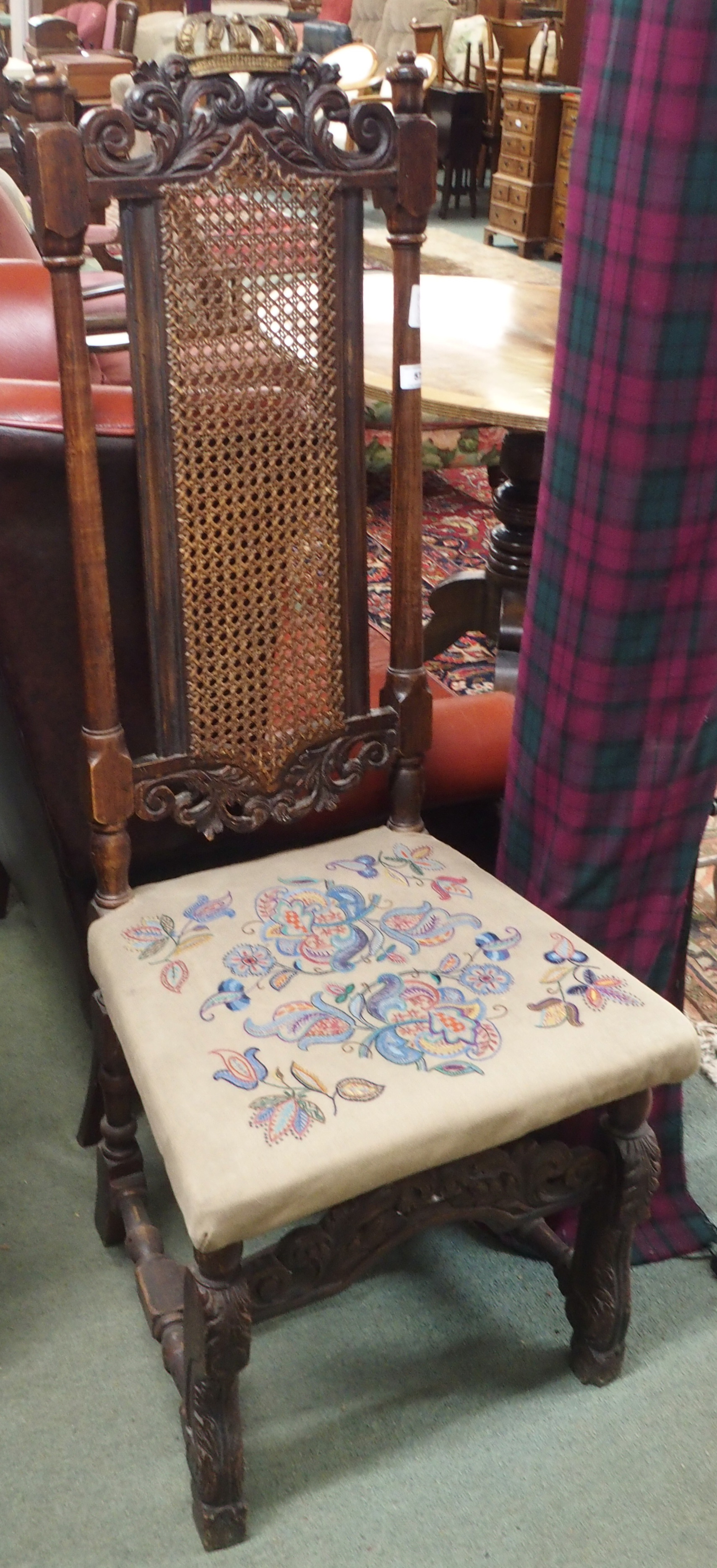 A carved hall chair with cane back and woolwork seat Condition Report: Available upon request