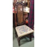A carved hall chair with cane back and woolwork seat Condition Report: Available upon request