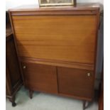 A teak cabinet with drop front and lower sliding doors Condition Report: Available upon request