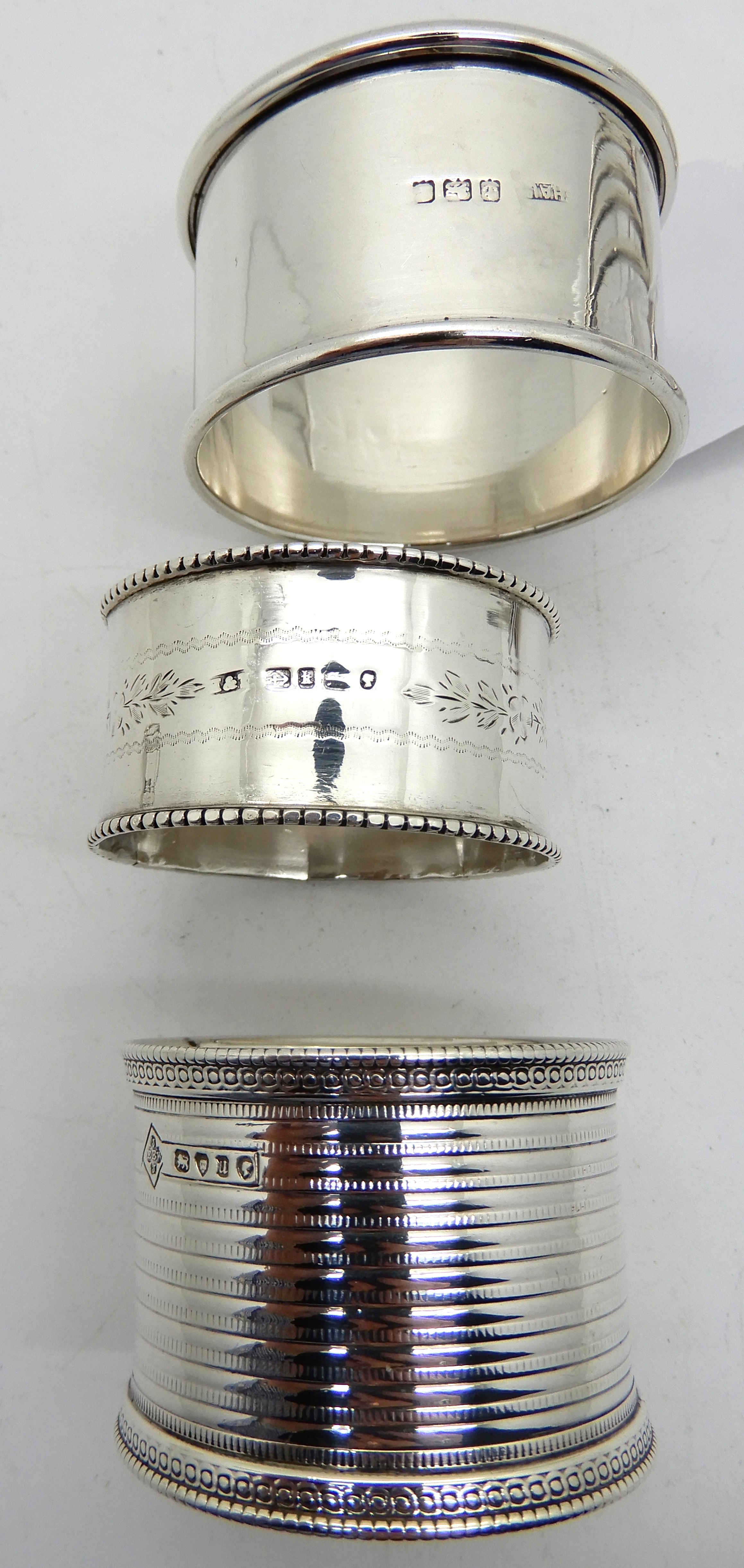 A lot comprising two silver toastracks, Birmingham marks and three silver napkin rings, assorted - Image 2 of 3