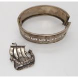 A Hamish Dawson Bowman Viking longship brooch, and a silver bangle Condition Report: Not available