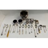 A lot comprising a silver plated vase, condiment set, loose cutlery and a white metal and enamel