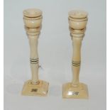 A pair of early 20th Century ivory candle sticks, 25cm high and a collection of other carved