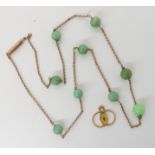 A 9ct gold chain strung with Chinese green hardstones and one green glass bead, together with a