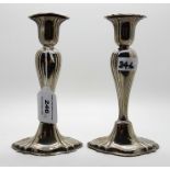 A pair of silver candlesticks, Birmingham 1903, the oval tapering stems with ribbed decoration on