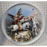 A continental hard paste porcelain circular plaque, decorated in relief with a man on horseback,