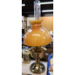 An oil lamp with amber glass shade Condition Report: Available upon request