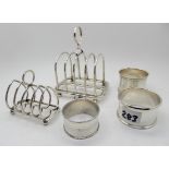 A lot comprising two silver toastracks, Birmingham marks and three silver napkin rings, assorted