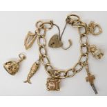 A 9ct gold charm bracelet, with five 9ct gold attached charms, and one loose and a yellow metal fish