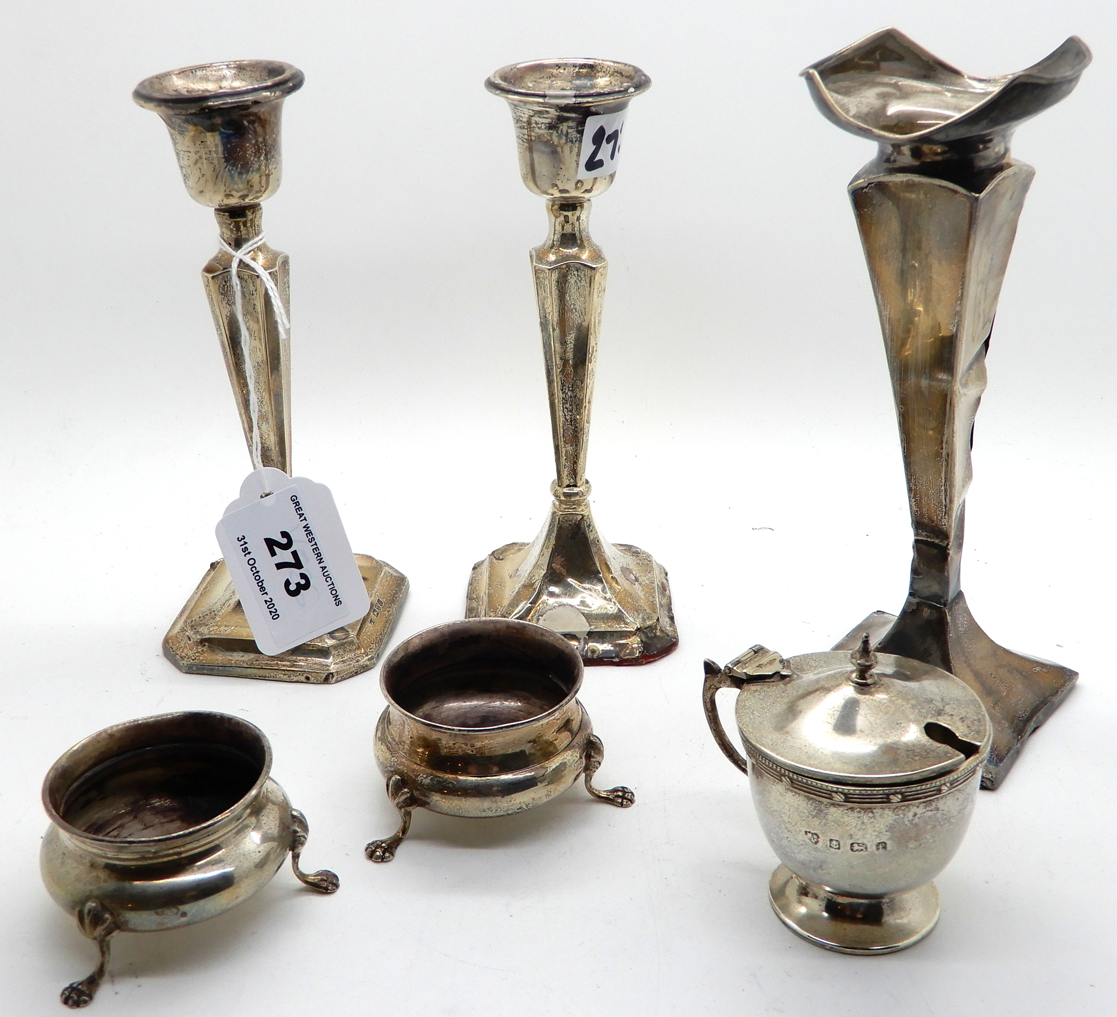 A lot comprising a silver vase (def), a pair of candlesticks (def), a mustard and two salts