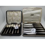 A lot comprising a cased set of six silver handled butter knives and a cased set of six silver