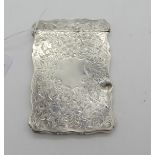 A silver card case, Birmingham 1909, rectangular with foliate engraving and blank cartouche (dent to