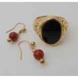 A 9ct gold onyx set decorative signet ring size O1/2 and a pair of yellow metal carnelian