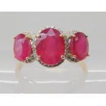 A 9ct yellow gold enhanced ruby trilogy ring, size S1/2, weight 3.1gms Condition Report: Available