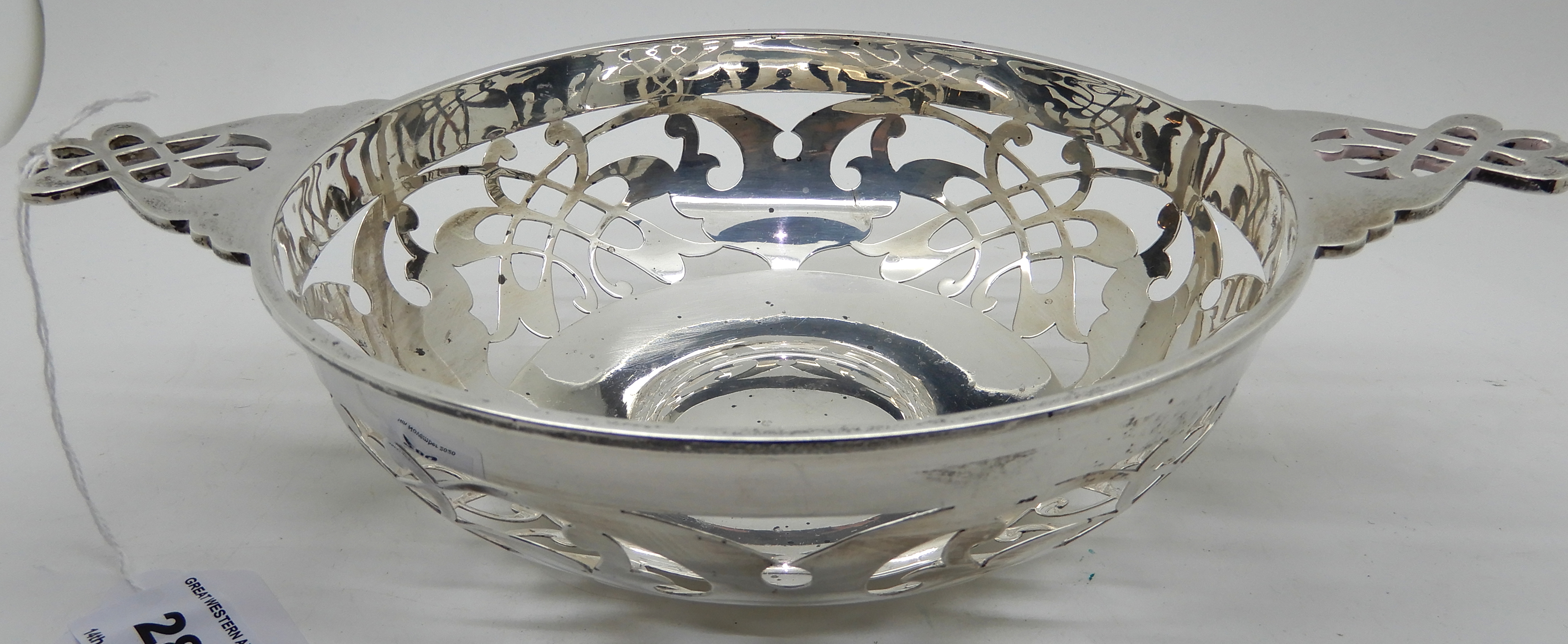A silver quaich style bowl with pierced decoration, 26.5cm across the lugs, Sheffield 1912, 323gms