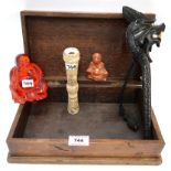 A carved wooden glove box containing a faux amber Buddha, a carved bone parasol handle, a dragon