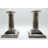 A pair of silver candlesticks, Sheffield 1913, with ribbed stems and beaded border, 12.7cm high,