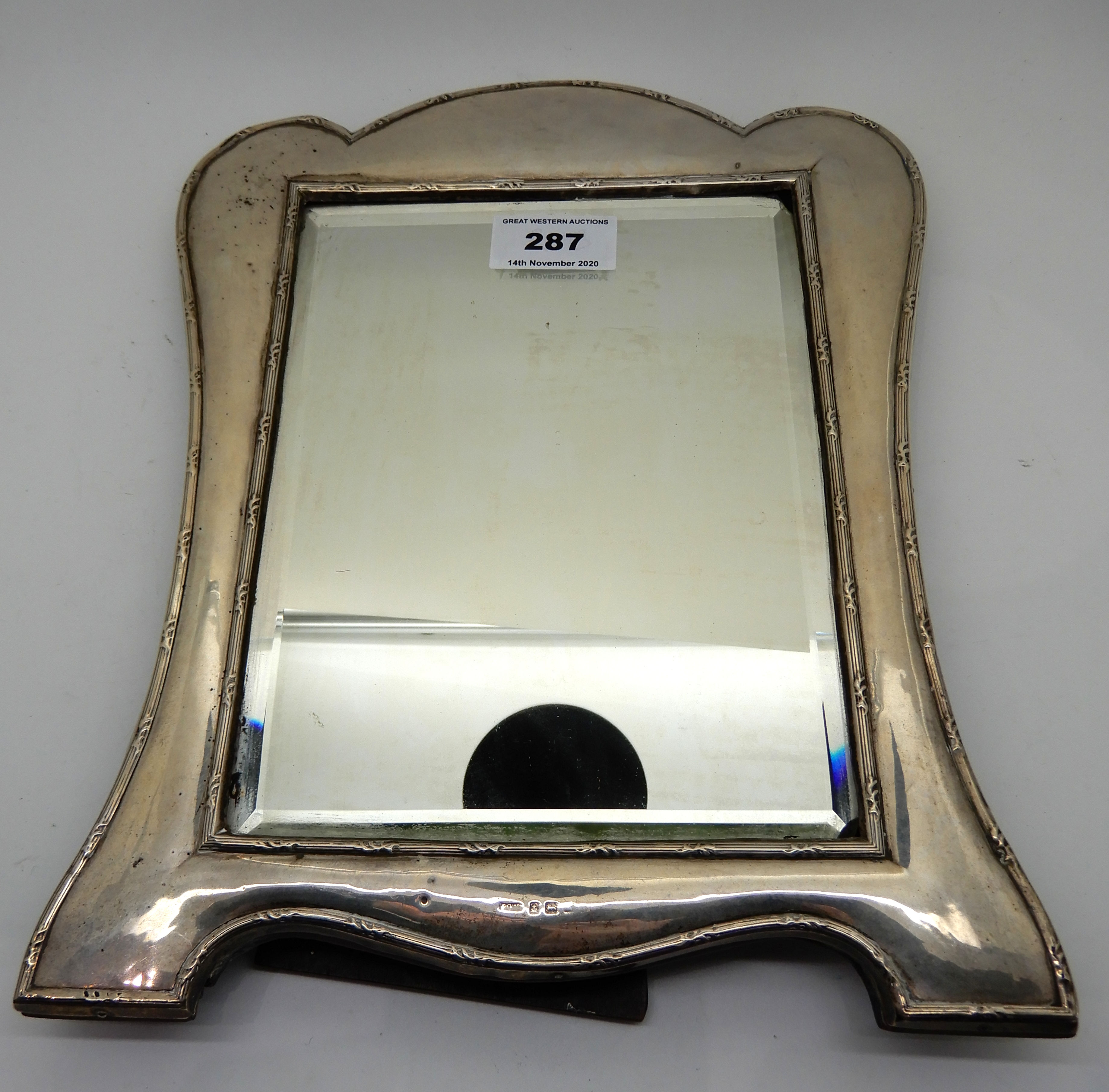 A silver mounted mirror, rubbed Birmingham marks, 30cm x 24cm, glass 20.3 cm x 15.3cm, damaged in