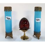 A Faberge red glass egg with cut and gilt decoration and a pair of blue glass spill vases