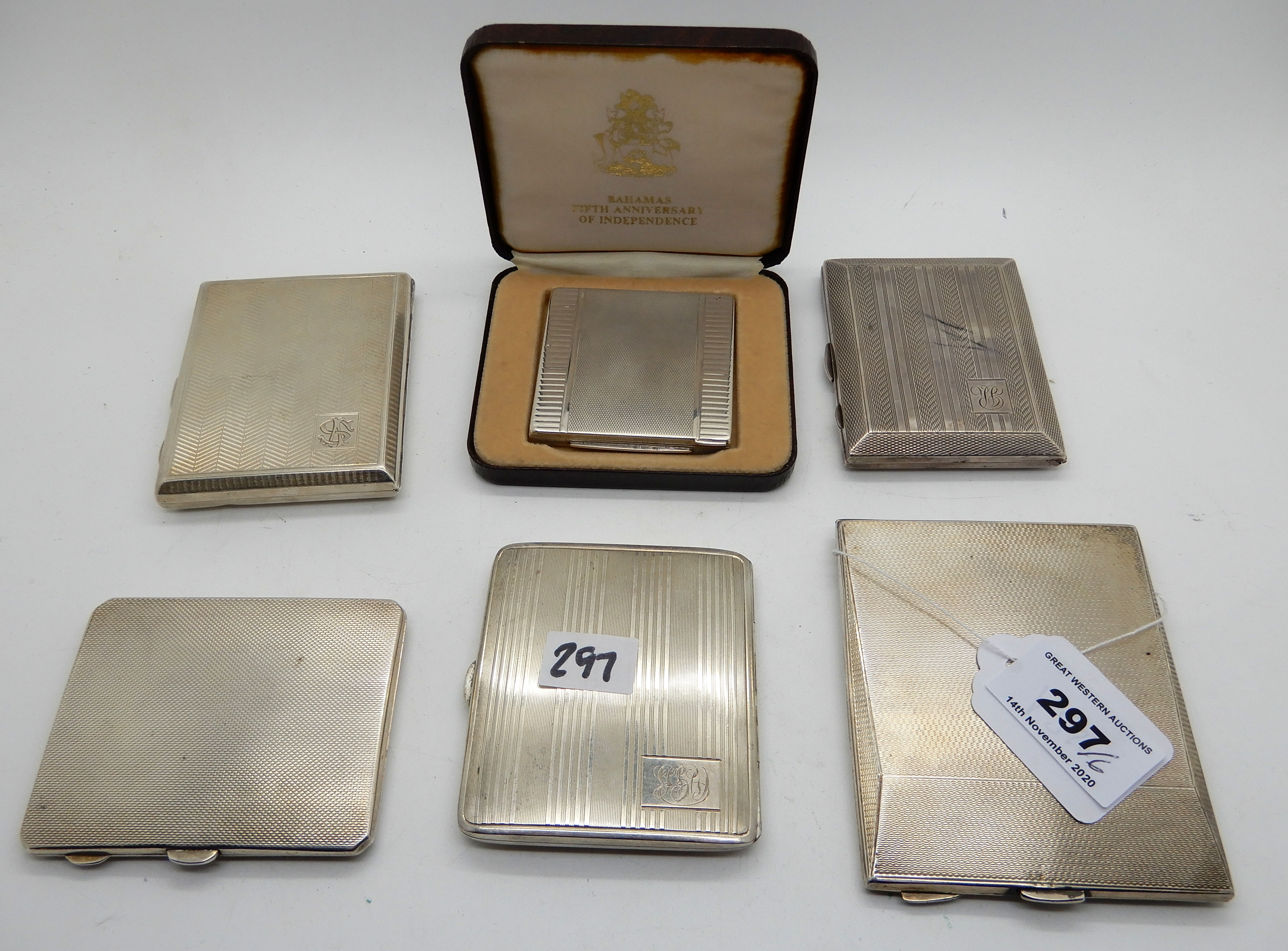A lot comprising five silver cigarette cases and a cased commemorative white metal compact, 497gms