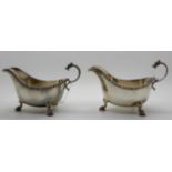 A pair of silver sauceboats, Birmingham 1937, with Celtic decoration, the scrolling handle