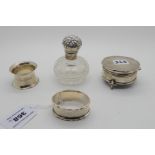 A lot comprising two silver napkin rings, a jewellery box and a silver topped scent bottle, assorted