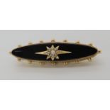 A yellow metal locket back onyx mourning brooch set with a pearl star, length 4.5cm, weight 6.6gms