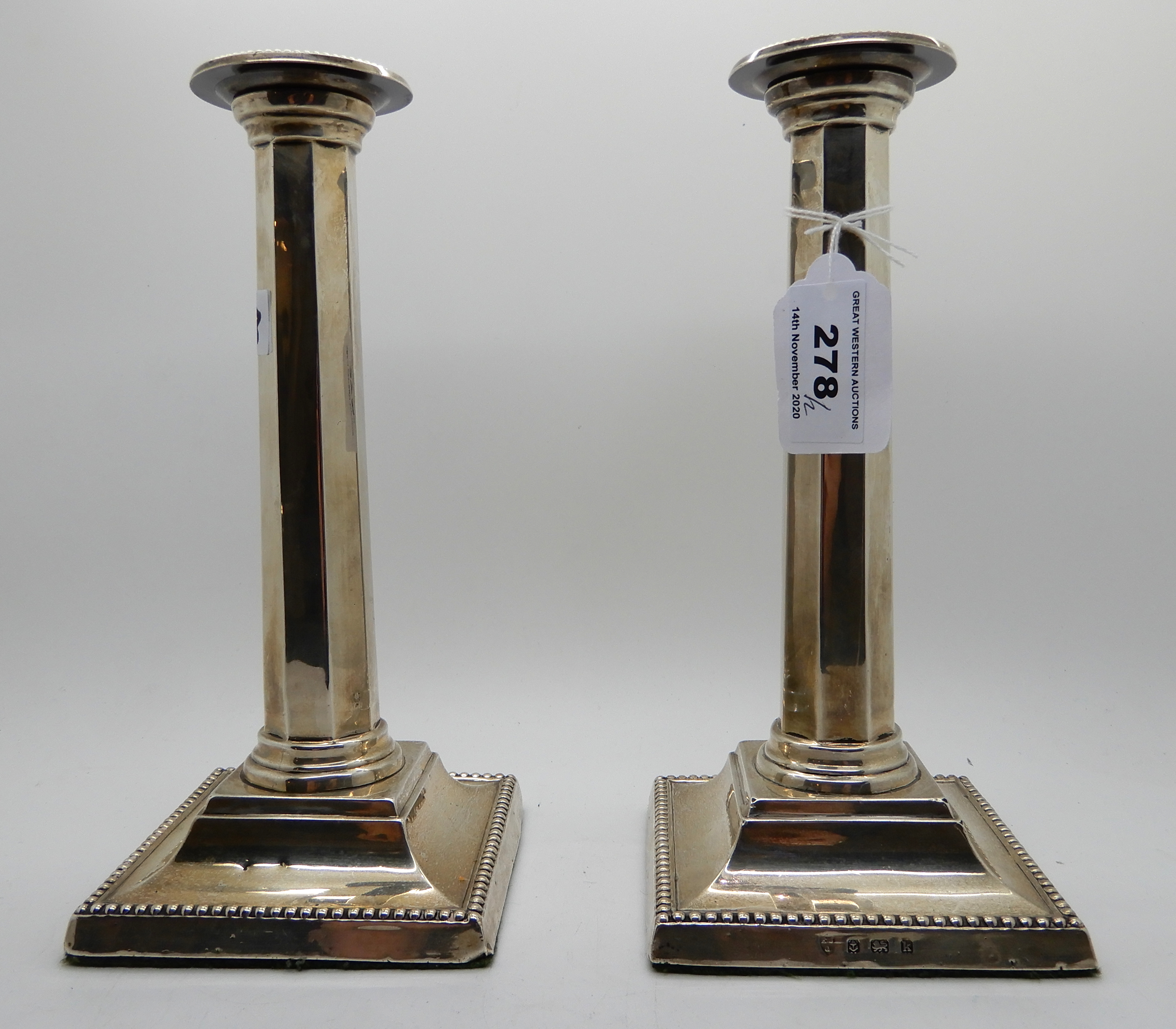 A pair of silver candlesticks, Birmingham 1909, the removable drip pans on tapering octagonal