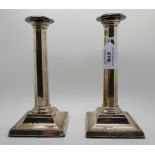 A pair of silver candlesticks, Birmingham 1909, the removable drip pans on tapering octagonal