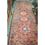 A red ground Karejeh runner with five central lozenges, 356cm x 104cm Condition Report: Available