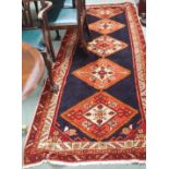 A blue ground Karajeh runner with five central lozenges, 310cm x 118cm Condition Report: Available