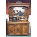 An Arts and Crafts oak sideboard with mirror back and carved panels and drawers, 220cm high x