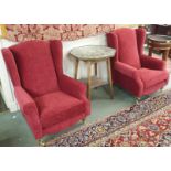 A pair of wingback armchairs with wine coloured upholstery with brass castors (2) Condition